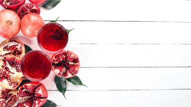 Taze nar suyu. Nar. Beyaz ahşap zemin üzerinde. Üstten Görünüm. Kopya alanı.