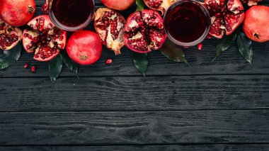 Taze nar suyu. Nar. Siyah ahşap arka plan üzerinde. Üstten Görünüm. Kopya alanı.