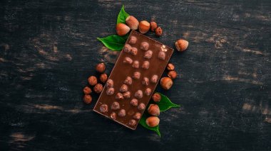 Koyu çikolata Fındıklı fındıklı. Kakao. Ahşap bir arka plan üzerinde. Üstten Görünüm. Metin için yer kopyalayın.