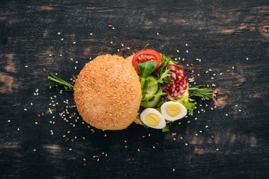 Hamburger, sandviç salam, bıldırcın yumurtası ve kiraz domates. Ahşap bir arka plan üzerinde. Üstten Görünüm. Kopya alanı.