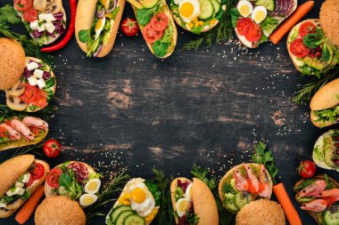 Burger ayarla, sandviç. Bıldırcın yumurta, salatalık ve Mısır, salam ve deniz ürünleri ile. Ahşap bir arka plan üzerinde. Üstten Görünüm. Kopya alanı.
