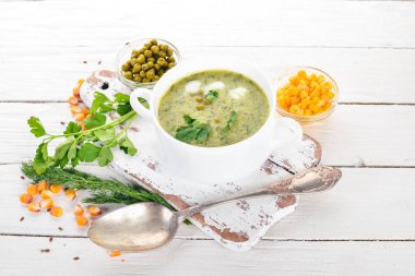 Brokoli ve bezelye ve bir kase sebze çorbası. Sağlıklı gıda. Beyaz ahşap zemin üzerinde. Üstten Görünüm. Metniniz için kopya alanı.