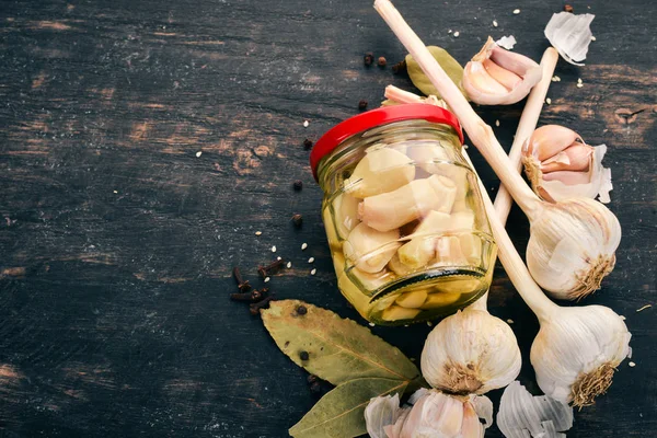 Marinated spicy garlic. On a black wooden background. Top view. Copy space for your text. — Stock Image Marinated Spicy Garlic Black Wooden Background Top View Copy Space Stock Picture
