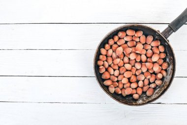 Bir tavada fındık. Beyaz ahşap zemin üzerinde. Üstten Görünüm. Metniniz için kopya alanı.