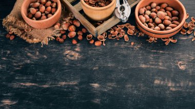 Kase fındık kümesi. Siyah ahşap arka plan üzerinde. Üstten Görünüm. Metniniz için kopya alanı.