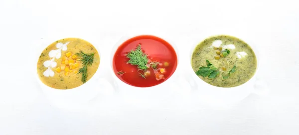Set of hot, colored vegetable soups. Broccoli soup, corn, tomato soup. Healthy food. On a white wooden background. Copy space. — Stock Image Set Hot Colored Vegetable Soups Broccoli Soup Corn Tomato Soup Royalty Free Stock Photos