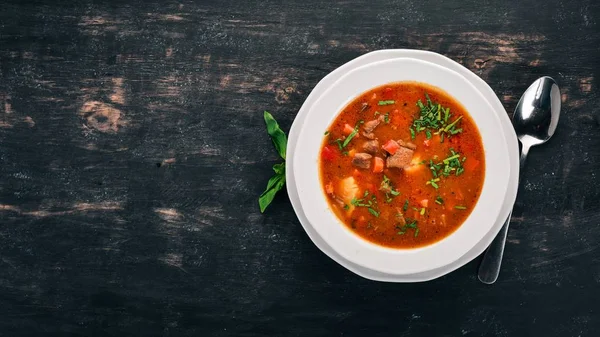 Soup with beef tomatoes and fresh vegetables. On a wooden background. Top view. Copy space. — Stock Image Soup Beef Tomatoes Fresh Vegetables Wooden Background Top View Copy Royalty Free Stock Images