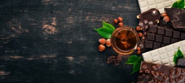 Bir bardak konyak, brendi, viski ve çikolata Çerezler ve tatlılar ile bir dizi. Siyah ahşap arka plan üzerinde. Metin için yer kopyalayın.