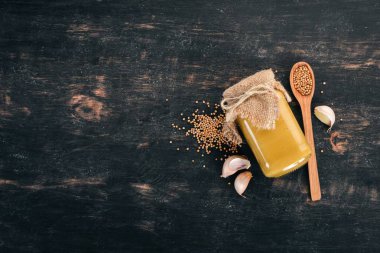 Hardal sosu. Baharat siyah bir ahşap zemin üzerine. Üstten Görünüm. Metniniz için kopya alanı.