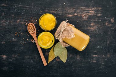 Hardal sosu. Baharat siyah bir ahşap zemin üzerine. Üstten Görünüm. Metniniz için kopya alanı.