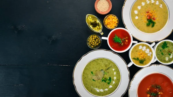 Set of hot, colored vegetable soups. Broccoli soup, corn, tomato soup. Healthy food. On a black wooden background. Copy space. — Stock Image Set Hot Colored Vegetable Soups Broccoli Soup Corn Tomato Soup Stock Photo