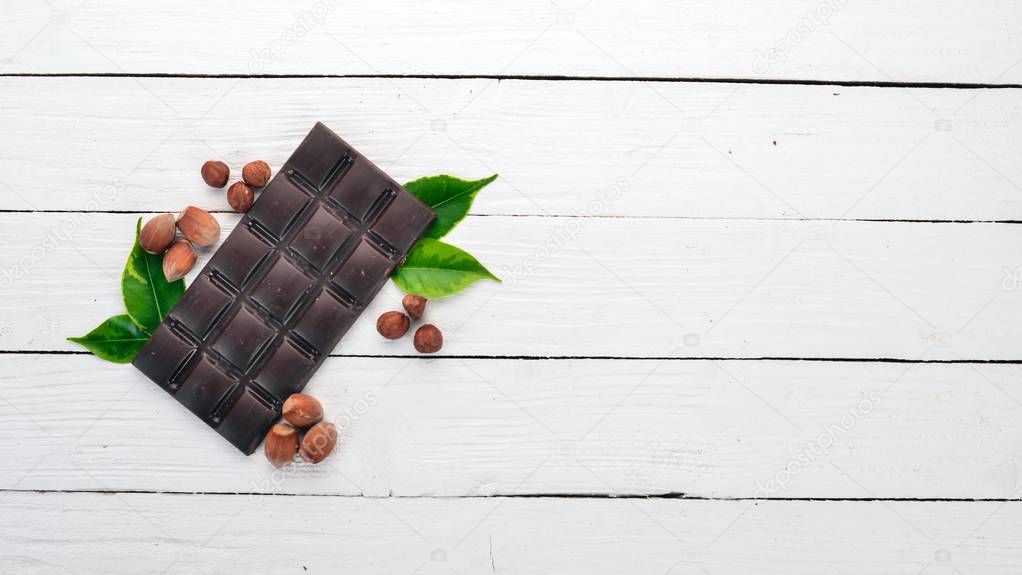 Dark chocolate with hazelnut nuts. Cacao. On a wooden background. Top view. Copy space for text.