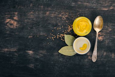 Hardal sosu. Baharat siyah bir ahşap zemin üzerine. Üstten Görünüm. Metniniz için kopya alanı.