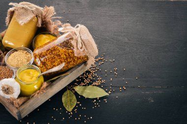 Hardal mezarda kümesi. Baharat siyah bir ahşap zemin üzerine. Üstten Görünüm. Metniniz için kopya alanı.