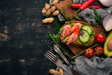 Burger, karides, avokado, havyar ve salatalık sandviç. Ahşap bir arka plan üzerinde. Üstten Görünüm. Kopya alanı.