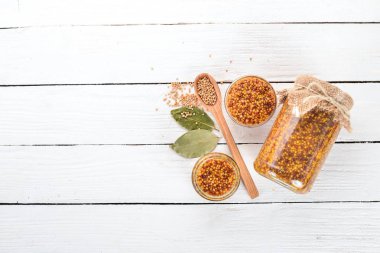 Tahıl hardal. Baharat beyaz ahşap zemin üzerinde. Üstten Görünüm. Metniniz için kopya alanı.