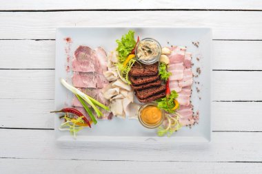 Et bir tabağa dilimlenmiş. Hardal, horseradish. Üstten Görünüm. Ahşap bir arka plan üzerinde. Kopya alanı.