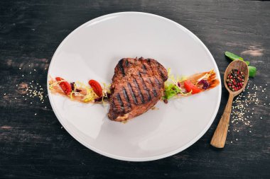 Sulu biftek bir ızgarada pişirilir. Üstten Görünüm. Ahşap bir arka plan üzerinde. Kopya alanı.