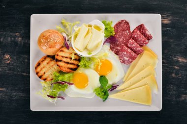 Kahvaltı. Pastırma ve domates, kızarmış ekmek ekmek ile yumurta. Üstten Görünüm. Ahşap bir arka plan üzerinde. Kopya alanı.