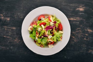 Peynir, fındık ve taze sebze salatası. Ahşap bir arka plan üzerinde. Üstten Görünüm. Metniniz için kopya alanı.