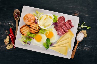 Kahvaltı. Pastırma ve domates, kızarmış ekmek ekmek ile yumurta. Üstten Görünüm. Ahşap bir arka plan üzerinde. Kopya alanı.