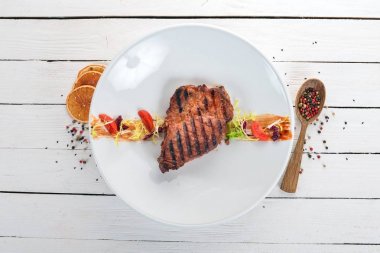 Sulu biftek bir ızgarada pişirilir. Üstten Görünüm. Ahşap bir arka plan üzerinde. Kopya alanı.