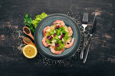 Kraliyet karides krem sos ve peynir. Bir plaka üzerinde deniz ürünleri. Üstten Görünüm. Siyah ahşap arka plan üzerinde. Kopya alanı.