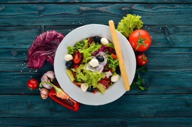 Mozzarella ve taze sebze salatası. Mavi ahşap arka plan üzerinde. Üstten Görünüm. Metniniz için kopya alanı.