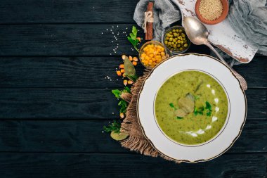 Brokoli ve bezelye ve bir kase sebze çorbası. Sağlıklı gıda. Siyah ahşap arka plan üzerinde. Üstten Görünüm. Metniniz için kopya alanı.