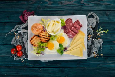 Kahvaltı. Pastırma ve domates, kızarmış ekmek ekmek ile yumurta. Üstten Görünüm. Ahşap bir arka plan üzerinde. Kopya alanı.