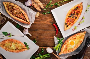 Khachapuri ve taze sebze ayarlayın. Gürcü mutfağı. Üstten Görünüm. Ahşap bir arka plan üzerinde. Kopya alanı.