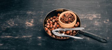 Bir tavada fındık. Siyah ahşap arka plan üzerinde. Üstten Görünüm. Metniniz için kopya alanı.