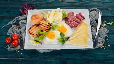 Kahvaltı. Pastırma ve domates, kızarmış ekmek ekmek ile yumurta. Üstten Görünüm. Ahşap bir arka plan üzerinde. Kopya alanı.