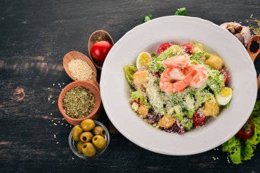 Sezar salata karides ile. Siyah ahşap arka plan üzerinde. Üstten Görünüm. Metniniz için kopya alanı.