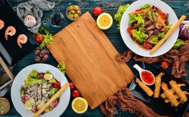 Yemek, salata karides ve et ile ürün yelpazesine. Ahşap bir arka plan üzerinde. Üstten Görünüm. Metniniz için kopya alanı.