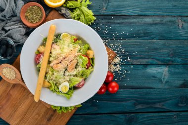 Tavuklu salata ve taze sebze. Sezar. Üstten Görünüm. Mavi ahşap arka plan üzerinde. Kopya alanı.