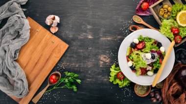 Mozzarella ve taze sebze salatası. Siyah ahşap arka plan üzerinde. Üstten Görünüm. Metniniz için kopya alanı.