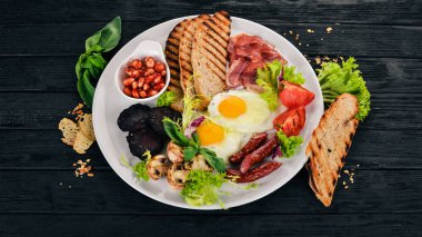 Kahvaltı. Pastırma ve domates, kızarmış ekmek ekmek ile yumurta. Üstten Görünüm. Ahşap bir arka plan üzerinde. Kopya alanı.