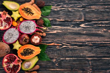 Tropikal meyveler, papaya, Dragon meyve, rambutan, demirhindi, kaktüs meyve, avokado, granadilla, carambola, Kamkat, mango, mangosten, Çarkıfelek, Hindistan cevizi. Ahşap bir arka plan üzerinde.
