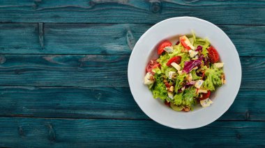 Peynir, fındık ve taze sebze salatası. Ahşap bir arka plan üzerinde. Üstten Görünüm. Metniniz için kopya alanı.