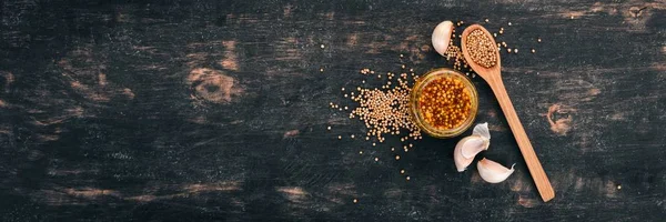 Grain Mustard. Spices On a dark wooden background. Top view. Copy space for your text.