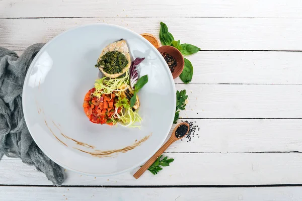 魚のフィレ肉のほうれん草ソースと蒸気の野菜 平面図です 木製の背景 コピー スペース — ストック写真