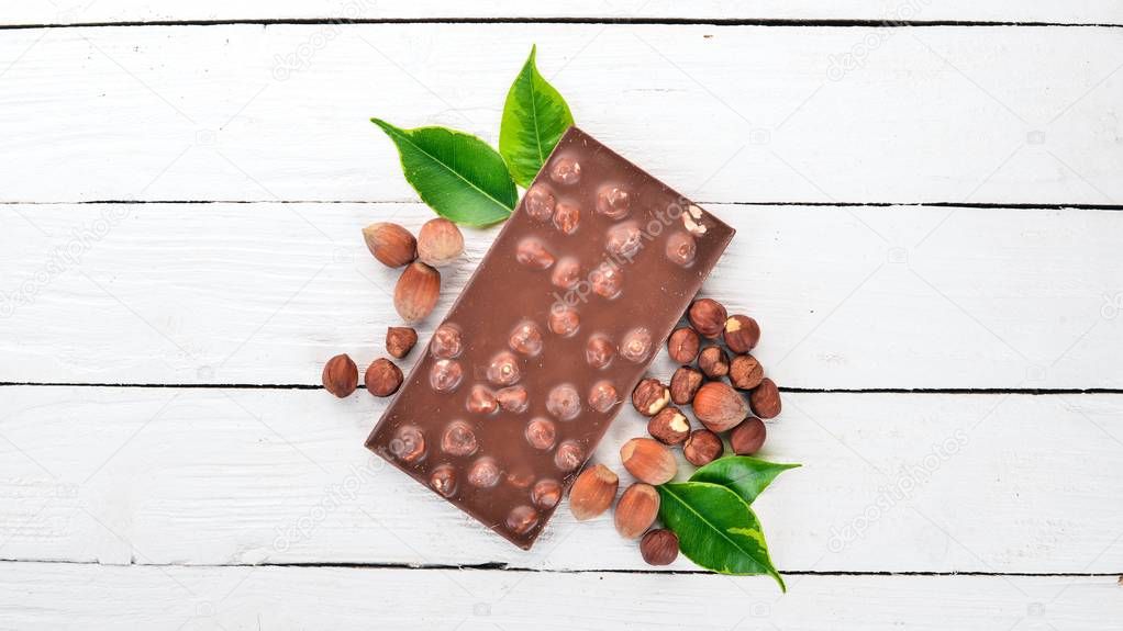 Dark chocolate with hazelnut nuts. Cacao. On a wooden background. Top view. Copy space for text.