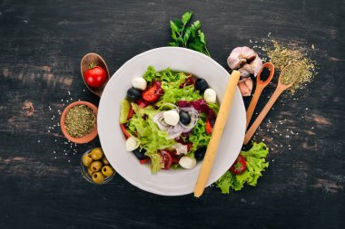Mozzarella ve taze sebze salatası. Siyah ahşap arka plan üzerinde. Üstten Görünüm. Metniniz için kopya alanı.