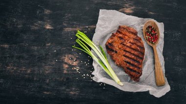 Sulu biftek bir ızgarada pişirilir. Üstten Görünüm. Ahşap bir arka plan üzerinde. Kopya alanı.