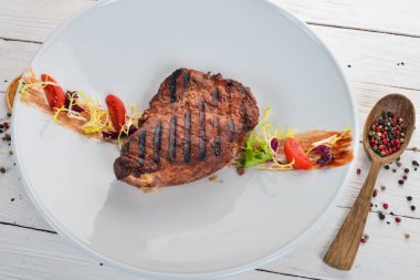 Sulu biftek bir ızgarada pişirilir. Üstten Görünüm. Ahşap bir arka plan üzerinde. Kopya alanı.