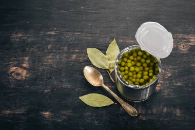 Bir kavanoz turşu yeşil bezelye. Gıda stokları. Üstten Görünüm. Ahşap bir arka plan üzerinde. Kopya alanı.