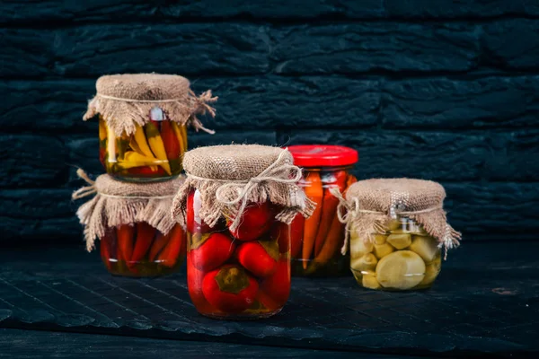 Pickled foods in cans. Stocks of food. Top view. On a wooden background. Copy space.