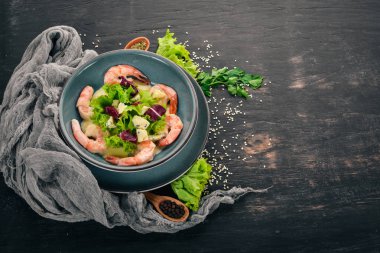 Kraliyet karides krem sos ve peynir. Bir plaka üzerinde deniz ürünleri. Üstten Görünüm. Siyah ahşap arka plan üzerinde. Kopya alanı.