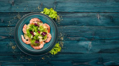 Kraliyet karides krem sos ve peynir. Bir plaka üzerinde deniz ürünleri. Üstten Görünüm. Mavi ahşap arka plan üzerinde. Kopya alanı.